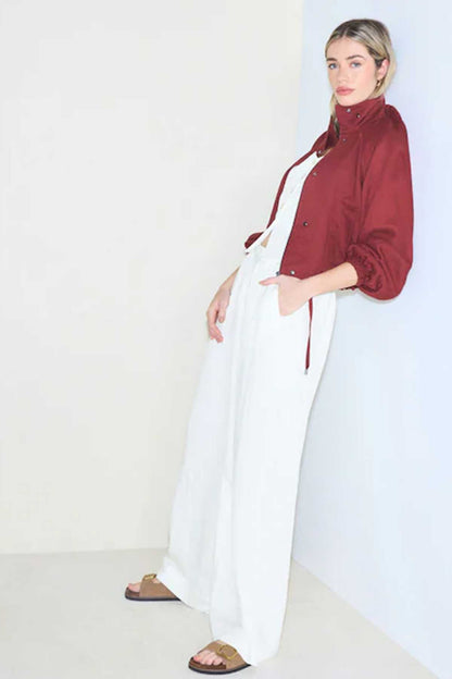 White wide-leg trousers with drawstring waist, worn with burgundy button jacket