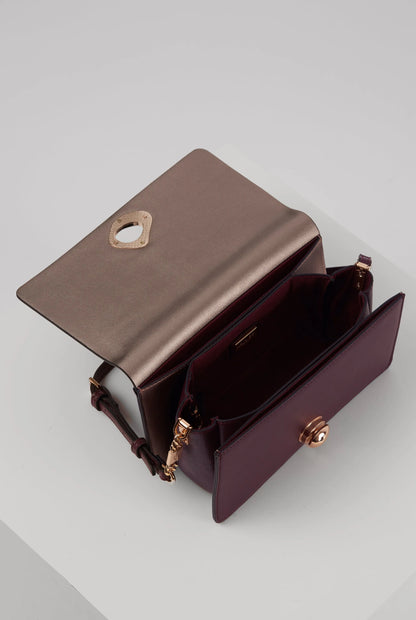 Open purple flap bag showing interior and gold hardware