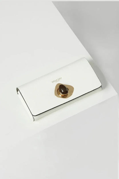 White leather flap clutch with gold button clasp
