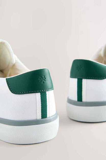 White NEXT sneakers heel with green pull tab and side stripe