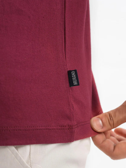 Maroon cotton T-shirt hem with black brand label and stitched edge
