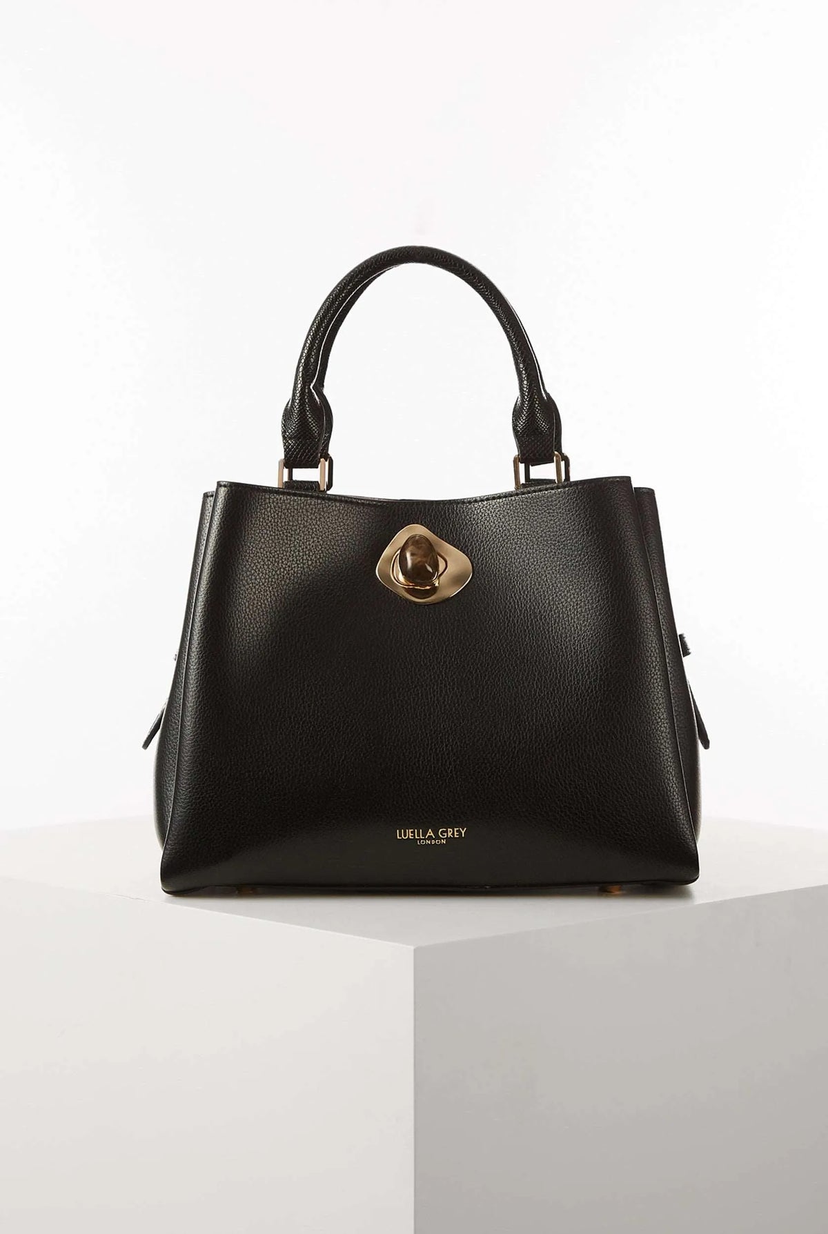 Black structured handbag with top handles and gold clasp closure