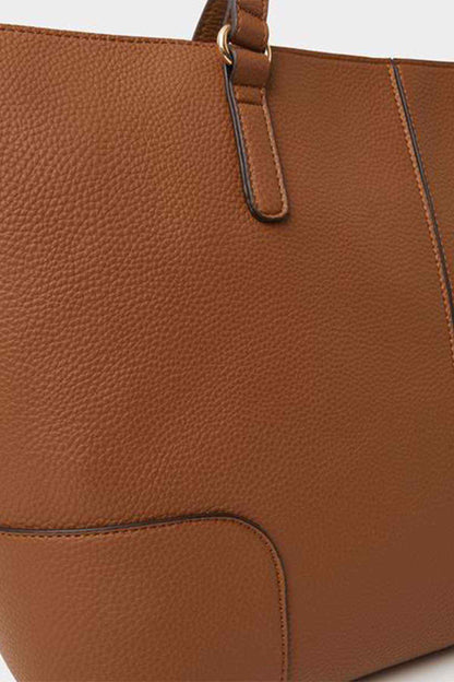 Tan leather-look tote bag close-up of textured surface and handle strap