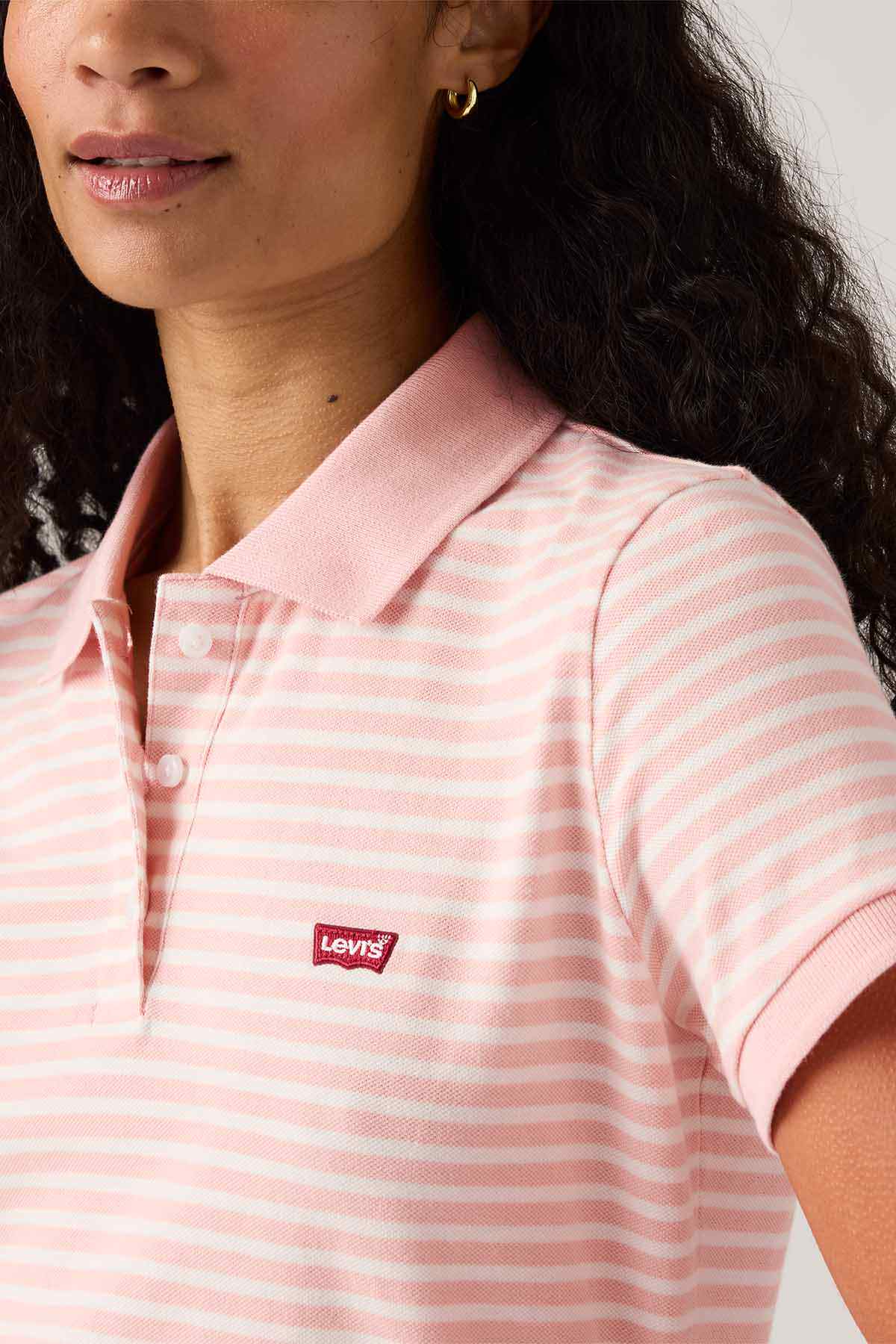 Pink striped polo shirt close-up with Levi's logo patch on chest and collar