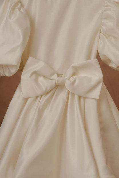 White dress close-up: large satin waist bow with gathered bodice