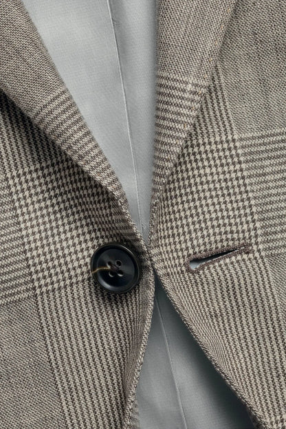 Light brown suit jacket lapel close-up with black button detail