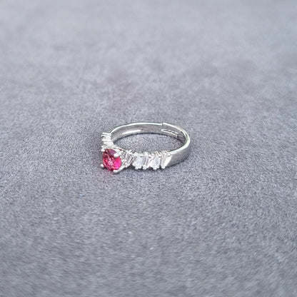 Silver-tone ring with red round center gemstone and white fringe detailing