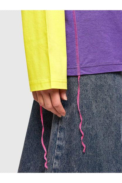 Long-sleeve top hem detail with pink contrast stitching and color-block panels