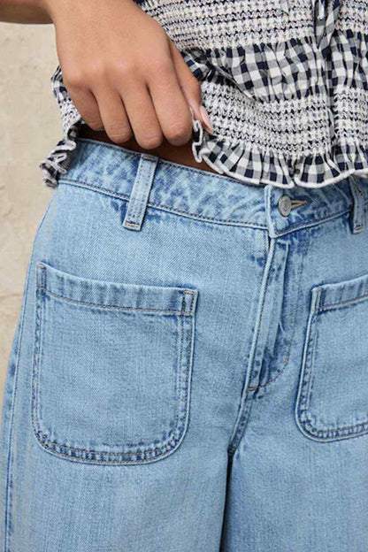 Light blue denim pants close-up with front patch pockets and belt loops.
