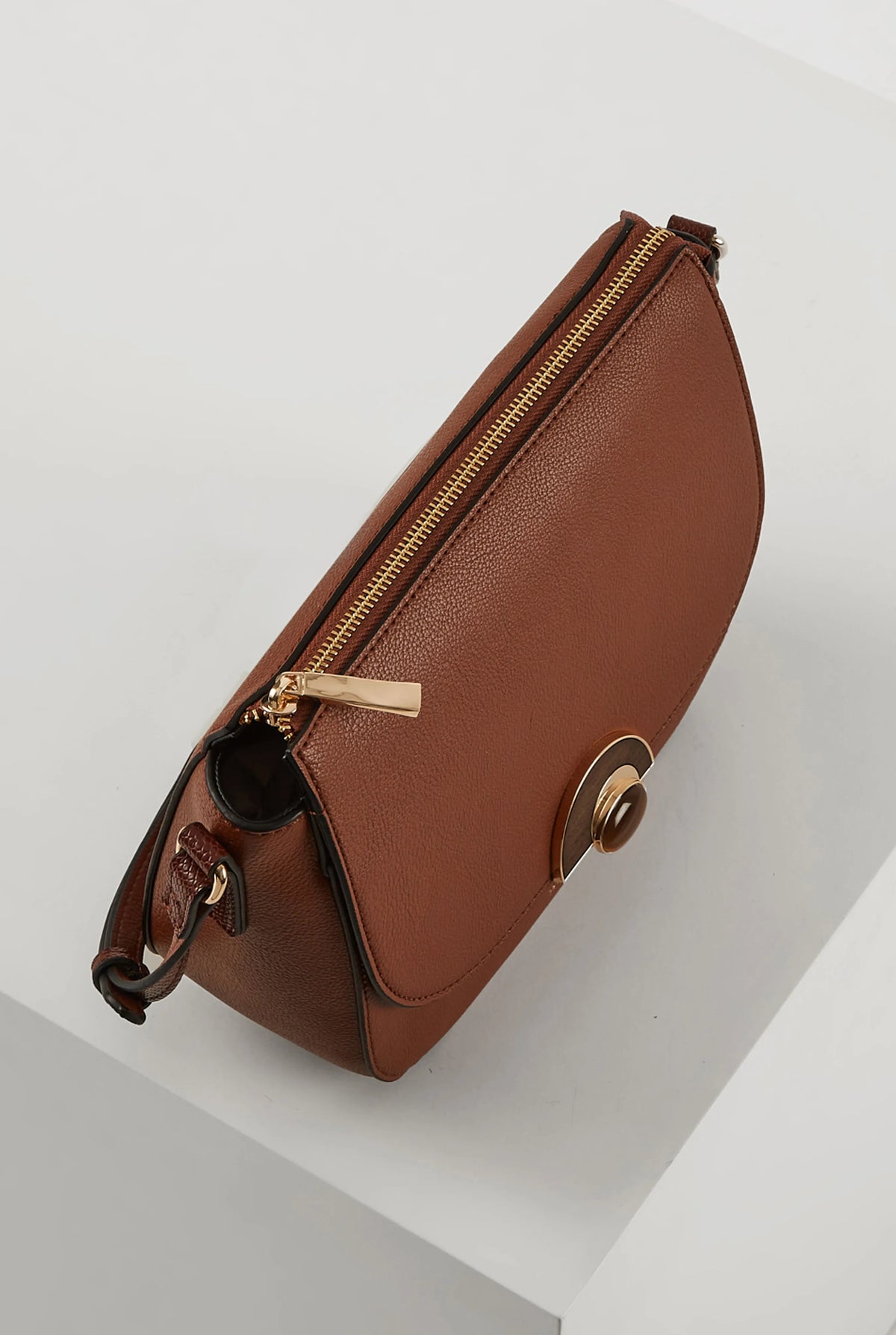 Brown crossbody bag side view with gold zipper and flap clasp