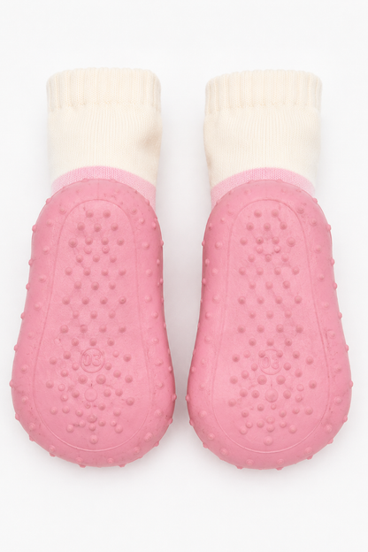 Pair of pink baby sock-shoes with cream cuffs and raised textured grip soles