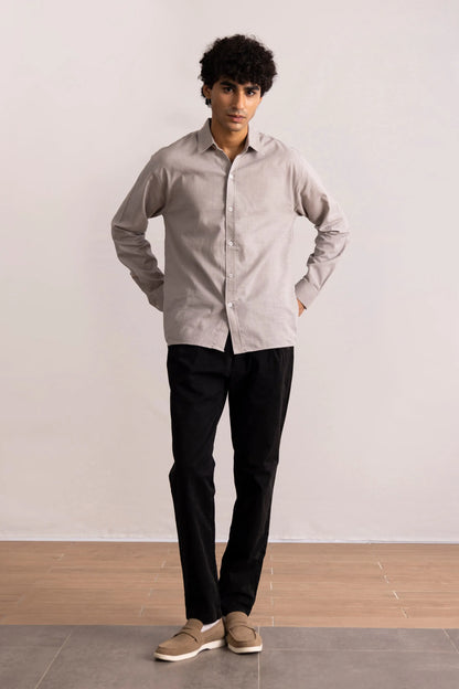 Grey button-up shirt on model with long sleeves and pointed collar, untucked hem
