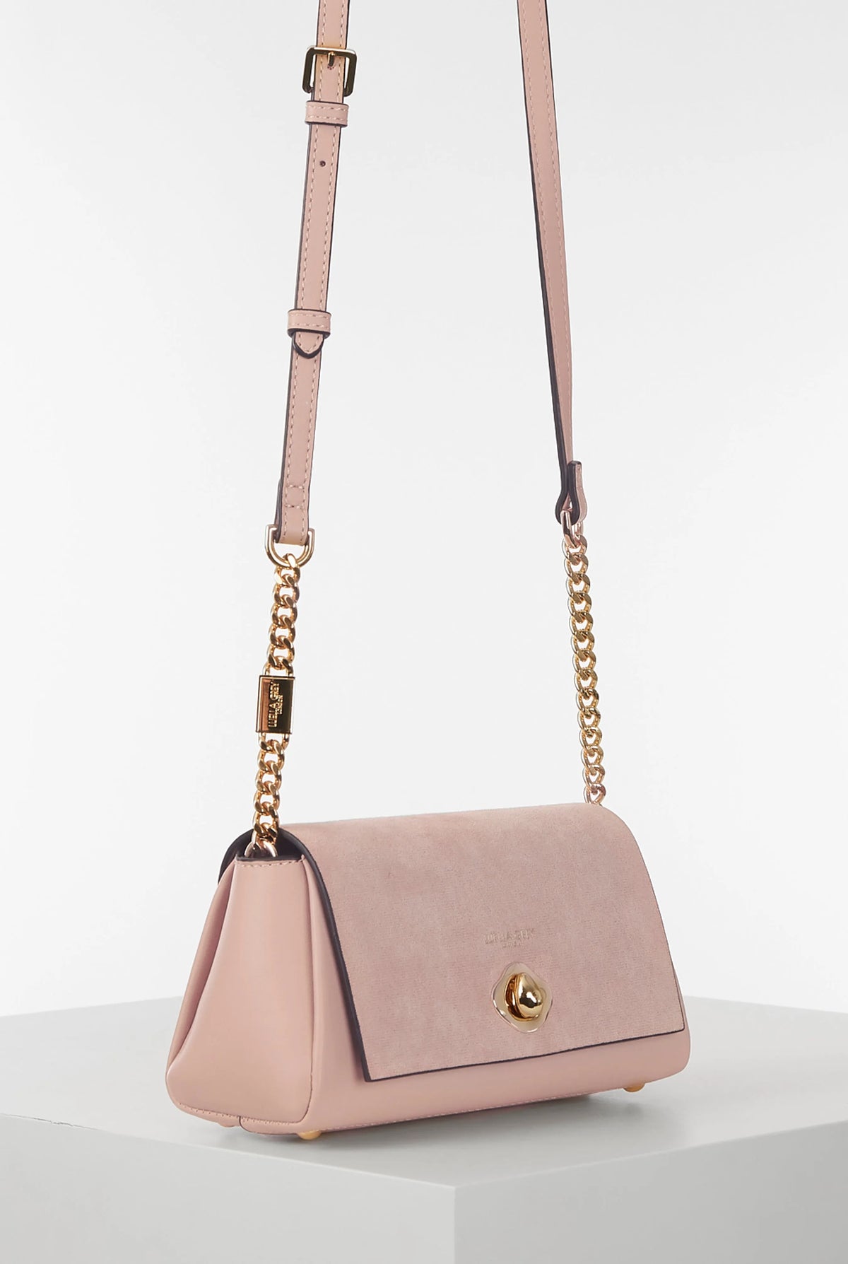 Pink shoulder bag with leather top handle and gold chain accents, front flap