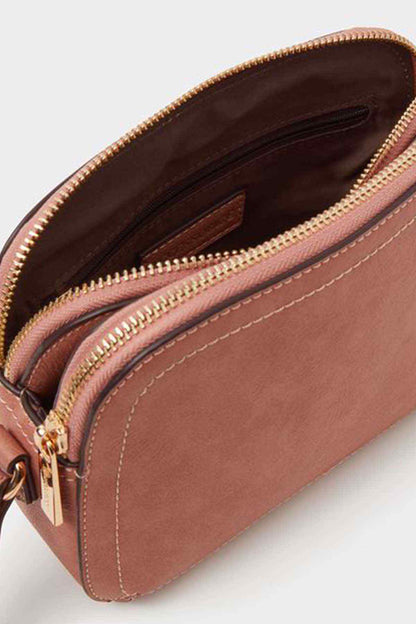 Dusty pink crossbody bag interior with zip pocket and stitched lining