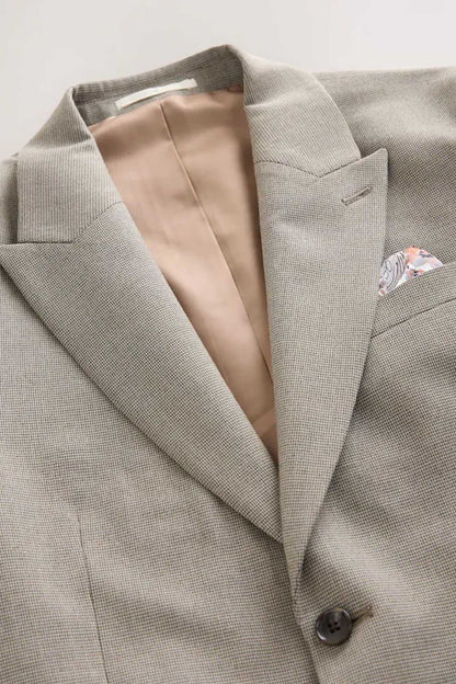 Men's gray suit jacket interior view with cream lining and welt front pocket.
