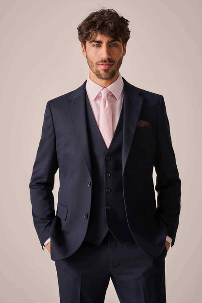 Men's navy suit jacket with dark buttons, waistcoat, and pink dress shirt