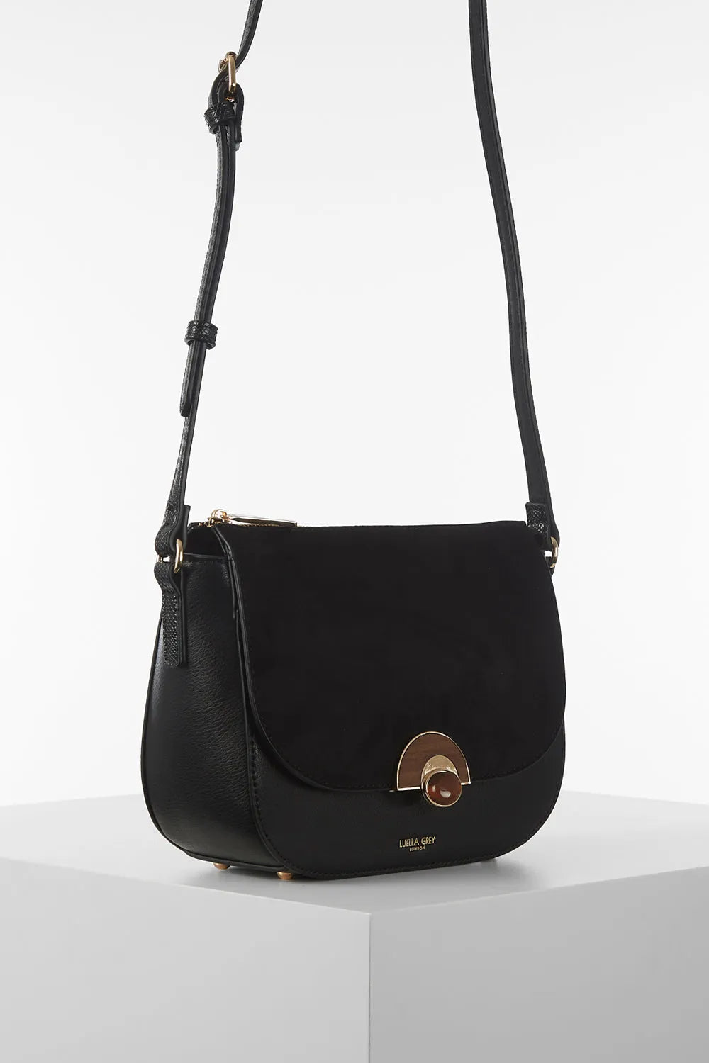 Black crossbody bag with rounded flap, gold-tone buckle, adjustable strap