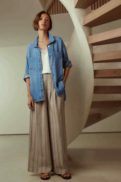 Next mid blue denim jacket with button placket and relaxed fit over striped trousers