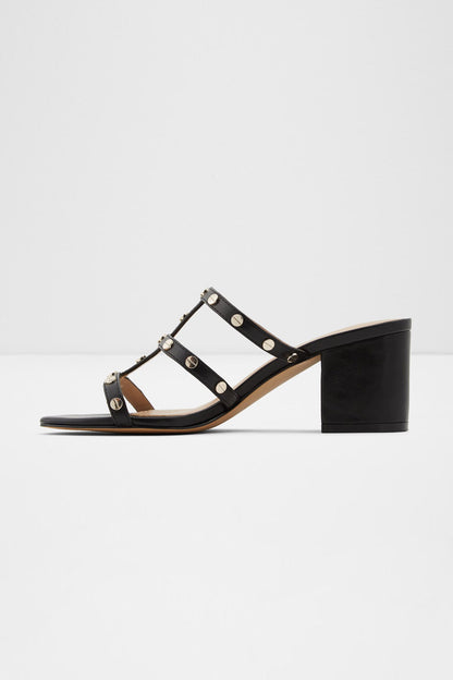 Black studded heeled sandals with open toe straps and round metal rivets, side view