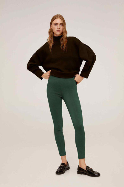 Mango black hoodie with long sleeves and green slim ankle pants, standing