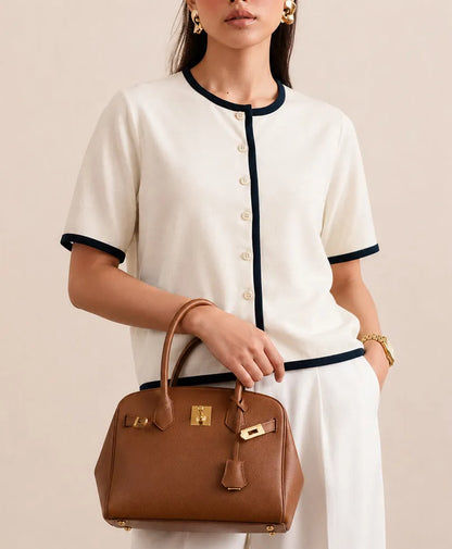 Fitted button-front knit top in cream with navy piping at neck and hem
