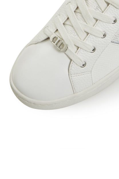 White sneaker close-up toe with lace eyelets and metal D-ring detail