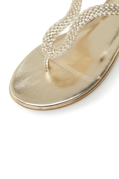 Gold metallic sandal close-up with braided toe thong and rope laces