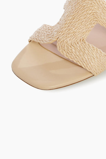 Natural raffia sandal with woven cross straps and flat tan footbed