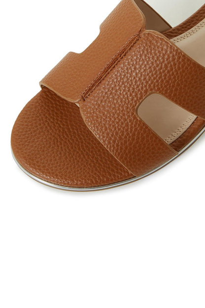 Tan leather slide sandal with textured finish, wide side straps, open toe
