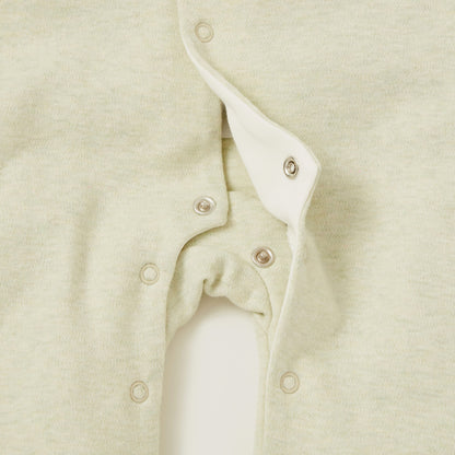 Baby romper close-up: sage fabric with snap buttons and curved open-leg design