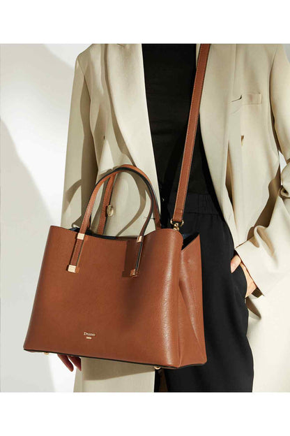 Dune London tan tote bag with top handles and crossbody strap, held by model