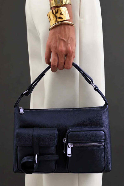 Midnight blue handbag with front flap panel, zip pocket, and top handles