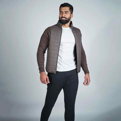 Dark brown quilted zip-up jacket with stand collar, worn over a white shirt