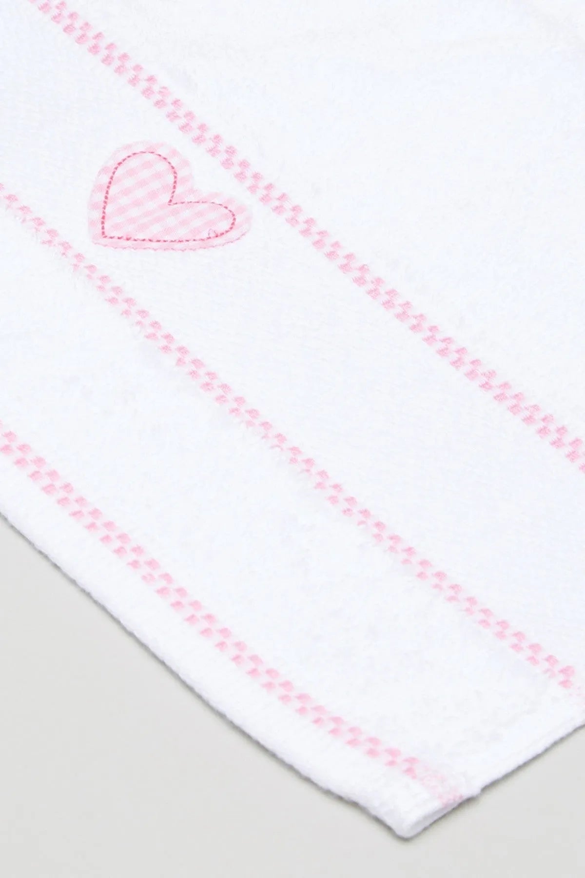 Baby blanket corner detail with pink heart applique and stitched stripes