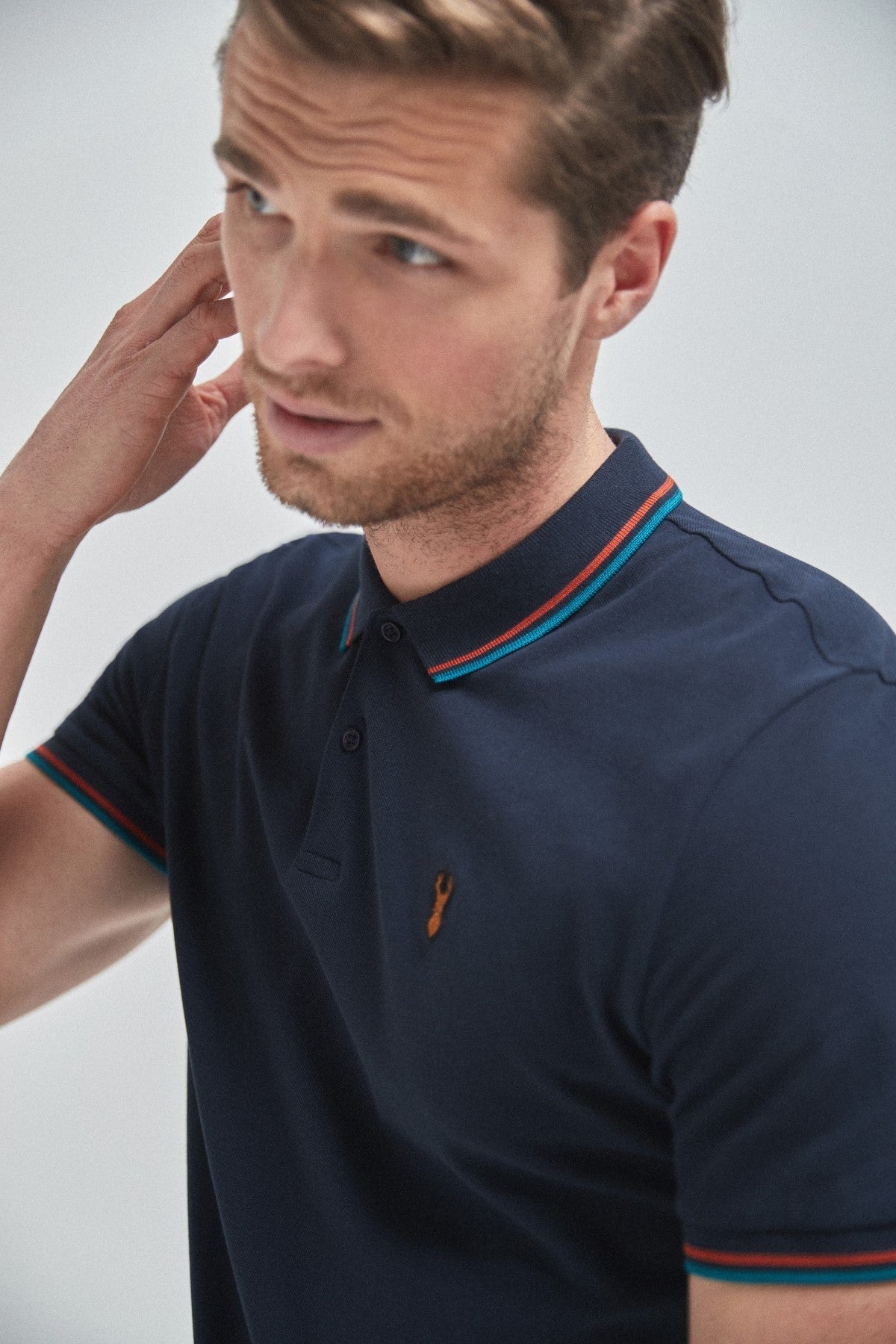 Navy short-sleeve polo shirt with button placket, collar trim, and small chest logo