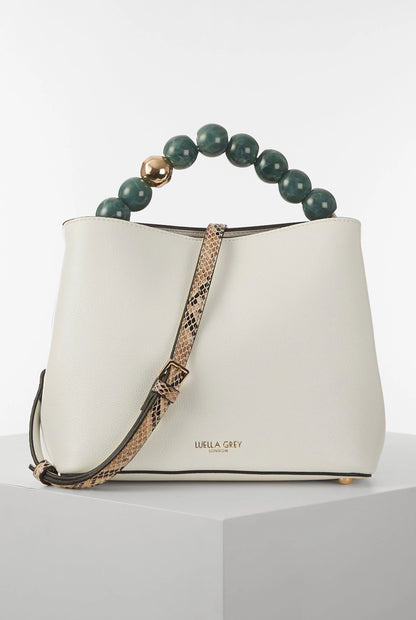 White bucket bag with green beaded handle and leopard-print crossbody strap, gold accents