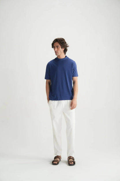 Blue crew-neck short-sleeve T-shirt with white pants, full-body view