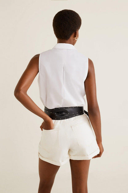 Off-white sleeveless shirt and shorts with black dotted belt, buttoned back