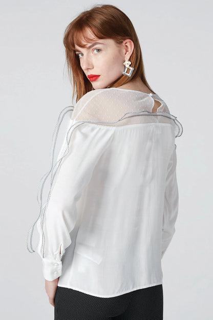 Back view of white sheer long-sleeve blouse with ruffled shoulder trim