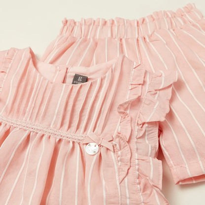 Close-up of pink striped baby dress bodice with ruffles and round button detail