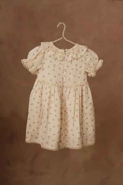 Cream floral baby dress with gathered waist, puff sleeves, and lace-trim hem