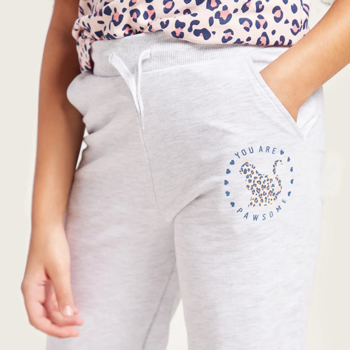 Grey sweatpants with drawstring and circular leopard graphic on thigh