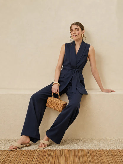 Navy sleeveless belted jumpsuit with layered front and wide-leg trousers
