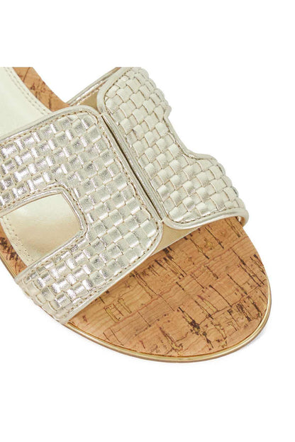 Close-up of gold metallic woven slide sandal strap with buckle detail