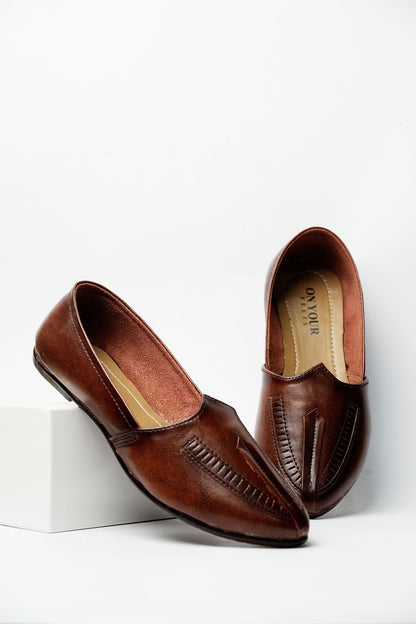 Brown leather slip-on loafers, angled side view with decorative stitching