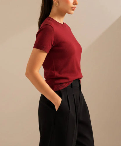 Fitted crew-neck knit top with short sleeves, burgundy red; side view with ribbed hem
