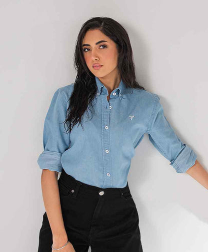Fitted light blue button-up shirt with long sleeves and black jeans