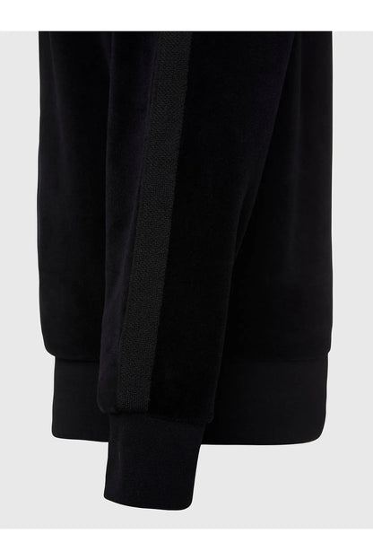 Black zip-up jacket sleeve and front panel detail with textured zipper