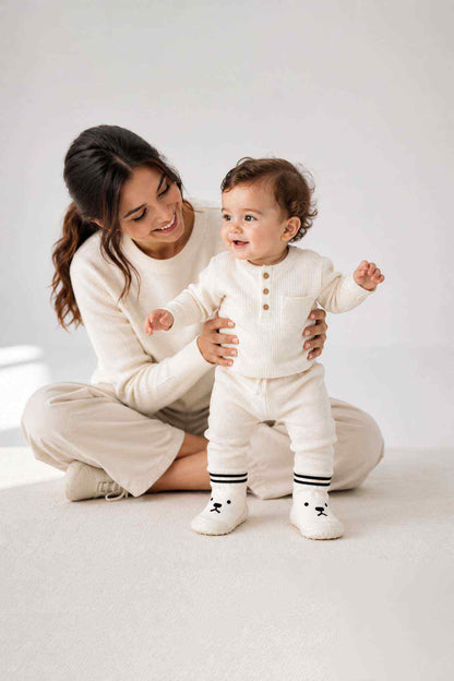 White ribbed baby bodysuit with round buttons and striped-knit socks