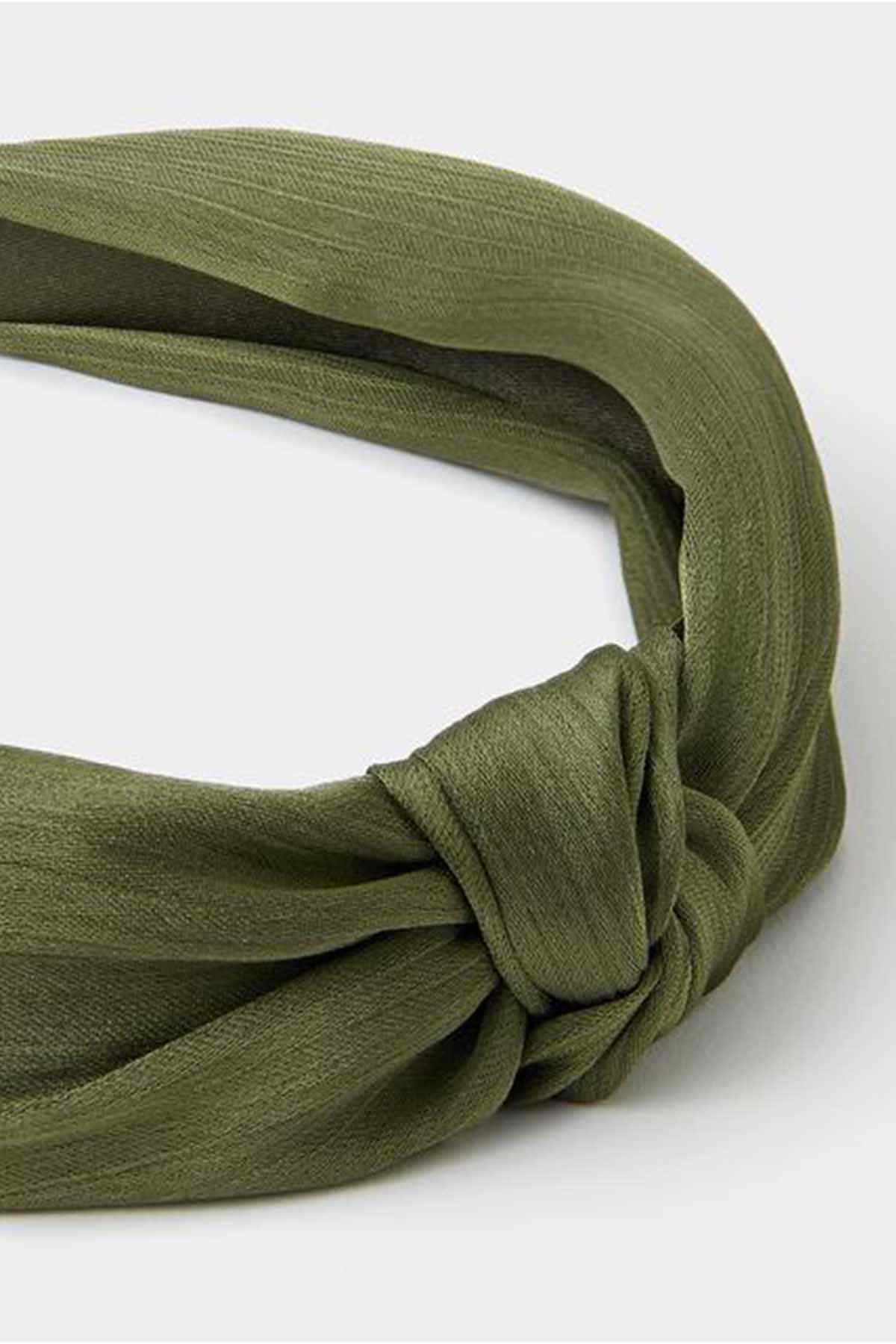 Khaki fabric headband close-up of knotted twist at center